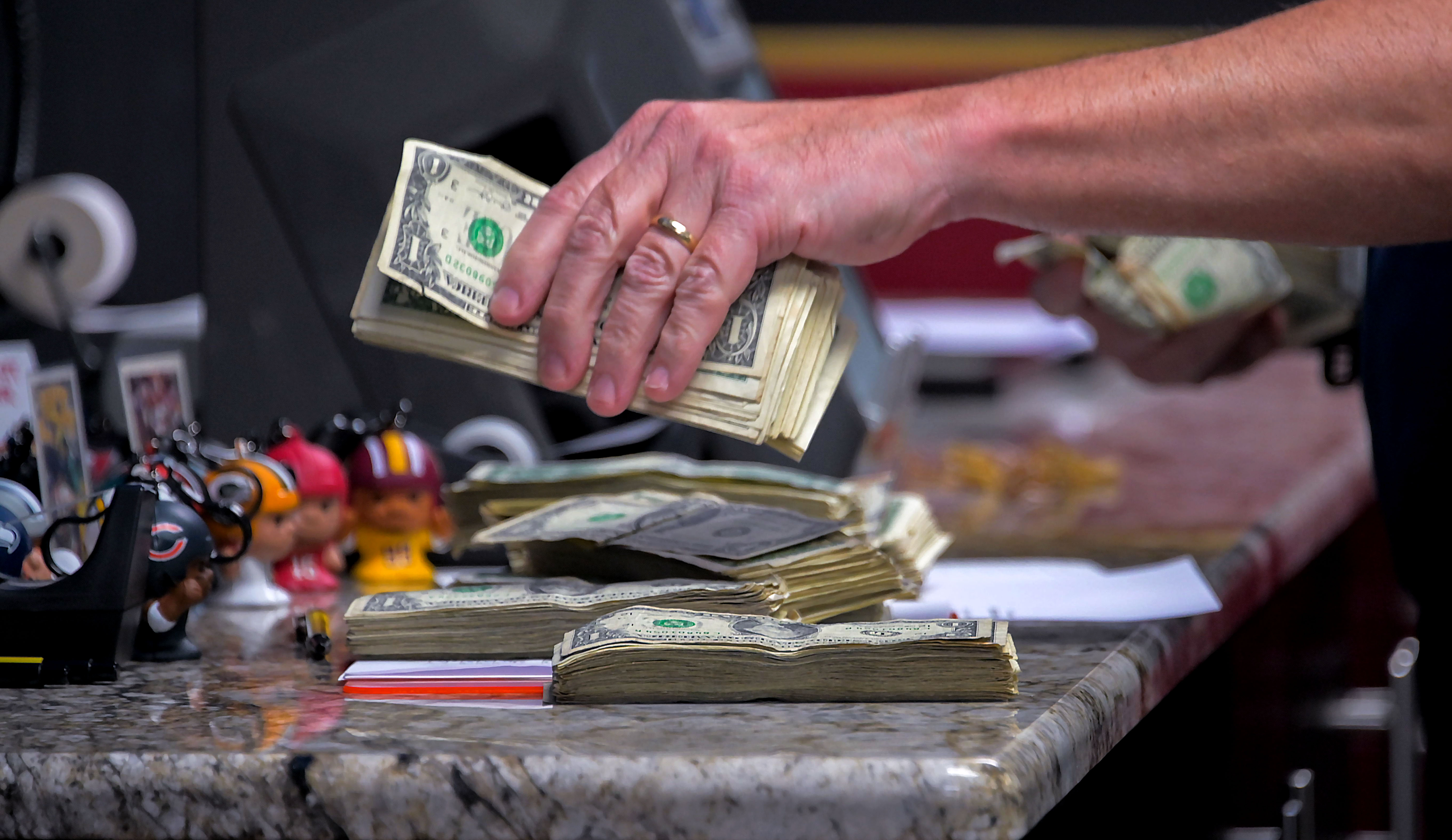 Employee Jeff Silverman counts dollars on Monday at BetRivers Sportsbook at Bingo World.