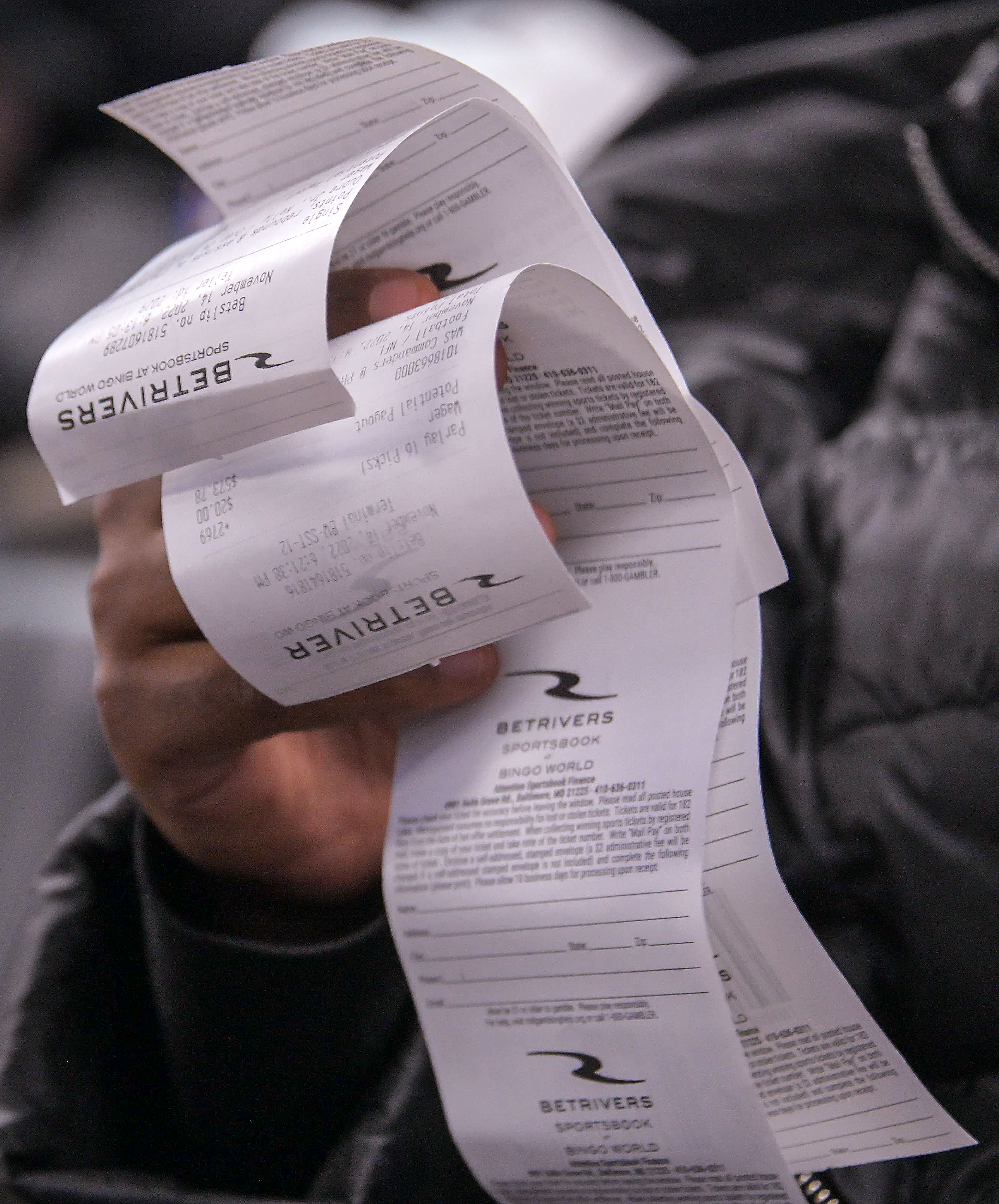 Leul Gebreyohannes of Catonsville holds betting receipts on Monday while watching games inside BetRivers Sportsbook at Bingo World.