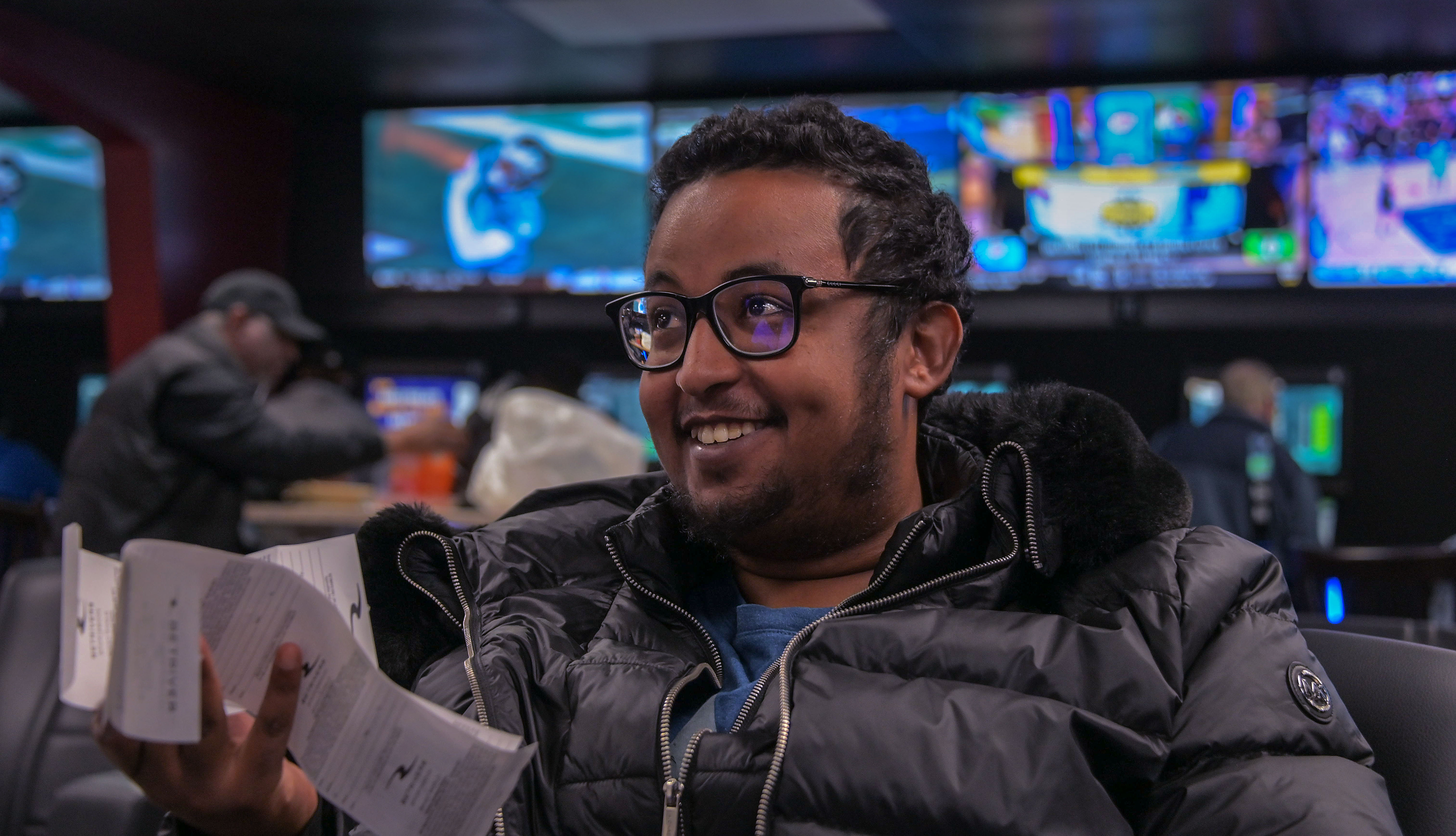 Leul  Gebreyohannes of Catonsville holds betting receipts while watching sports broadcasts inside BetRivers Sportsbook at Bingo World Monday.