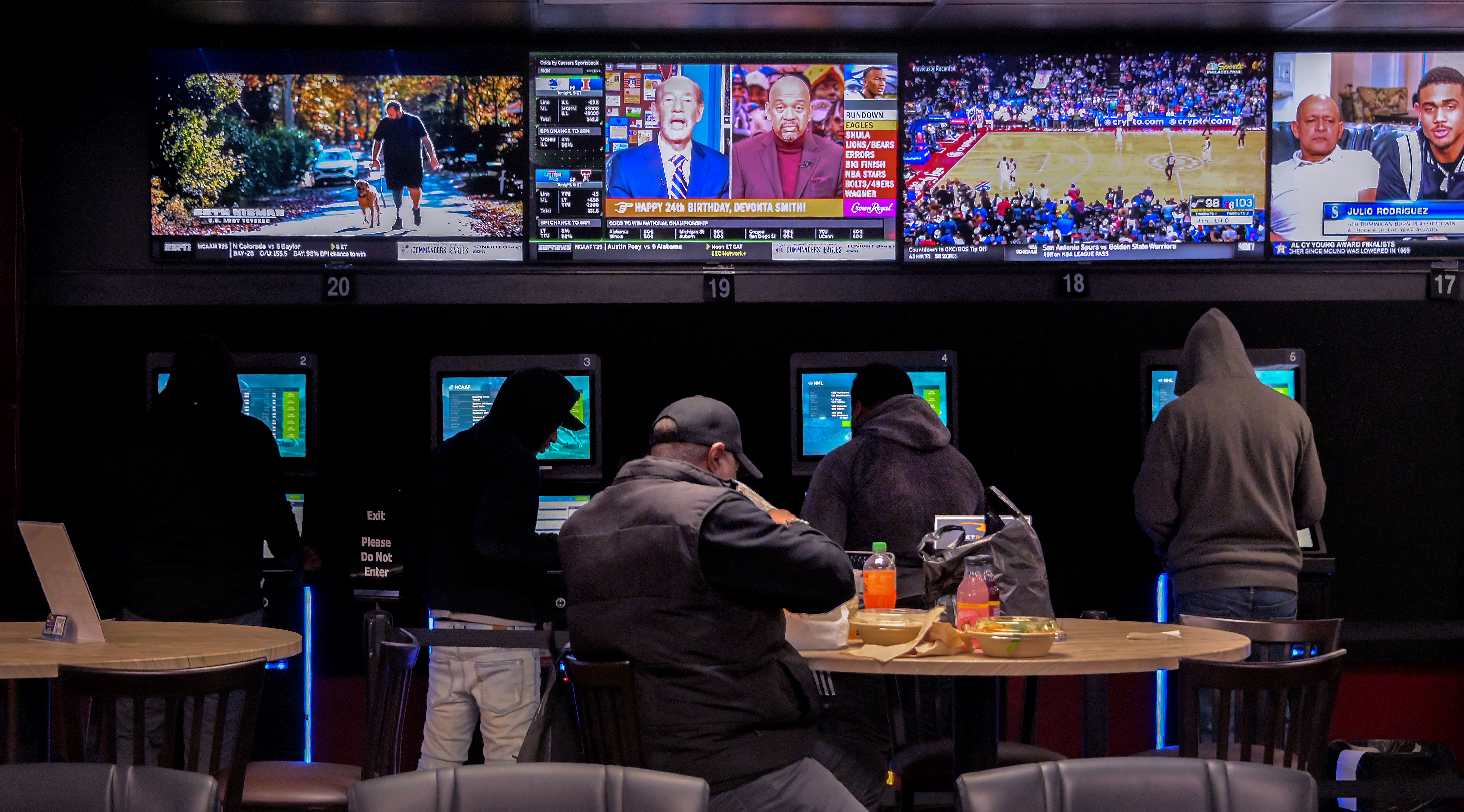 Monitors display live games while visitors use sports betting kiosks inside BetRivers Sportsbook at Bingo World.